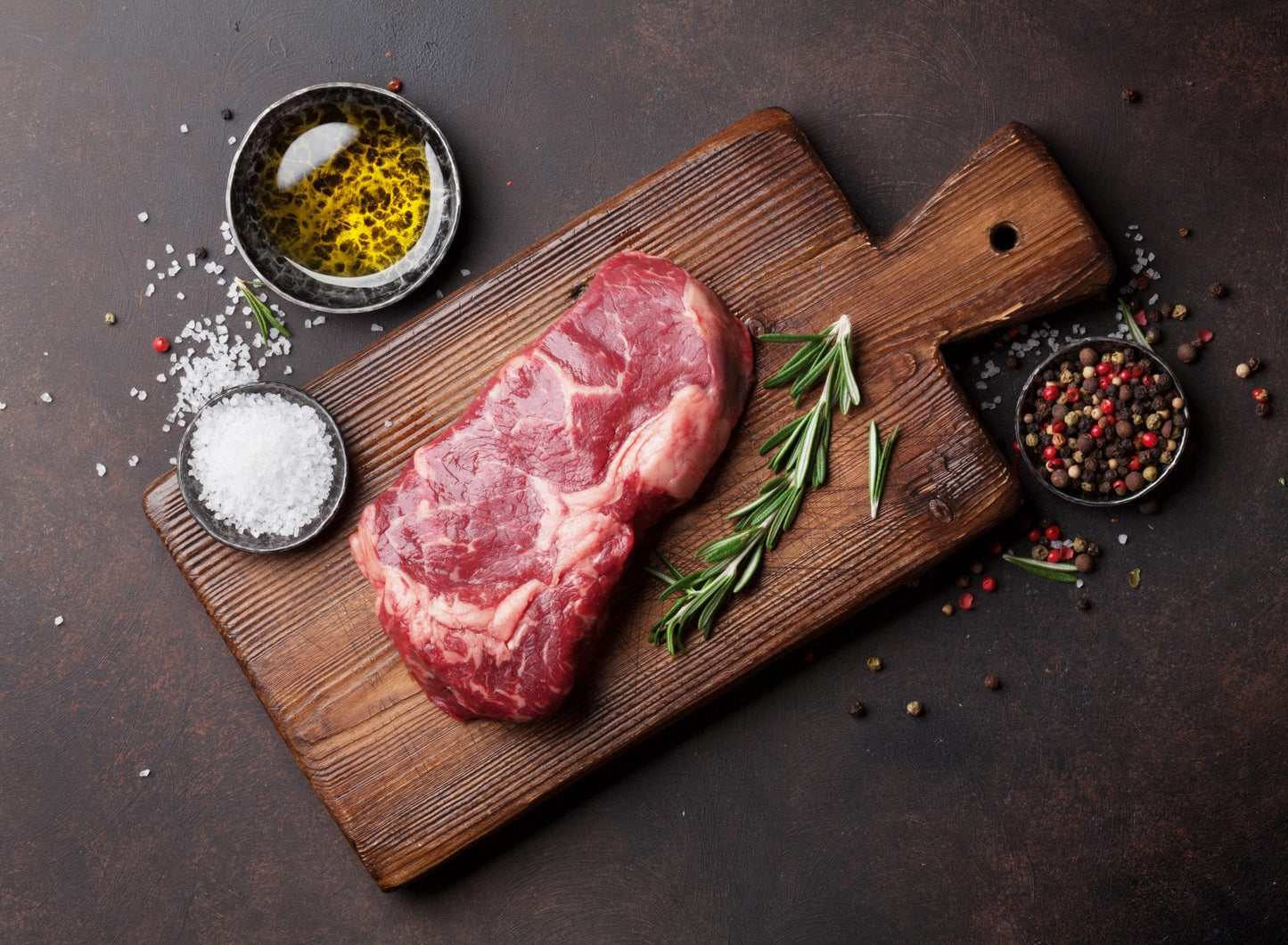 Raw ribeye beef steak cooking with ingredients