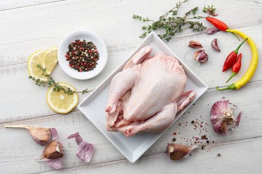 Raw chicken, herbs and spices on white wooden background